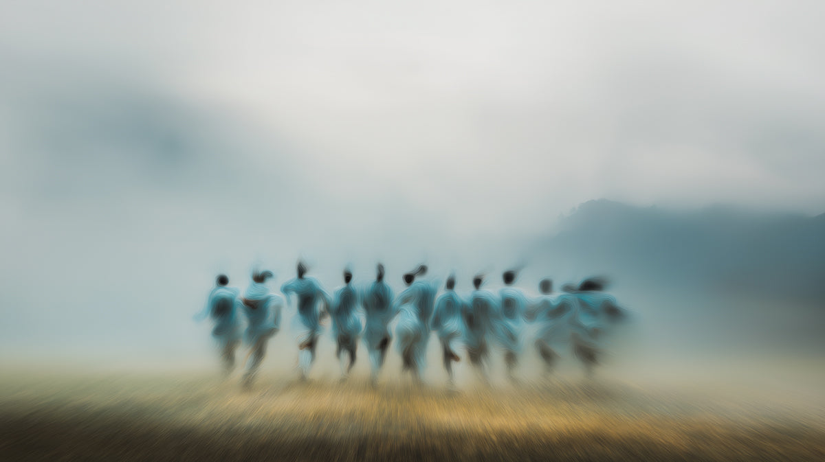 Abstract impressionist mural featuring blurred human figures emerging from gray fog over a warm golden earth tone.