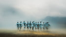Abstract impressionist mural featuring blurred human figures emerging from gray fog over a warm golden earth tone.
