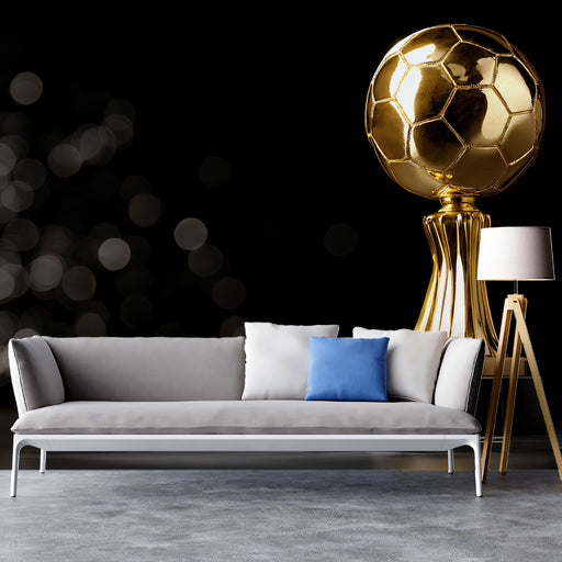 Gray sofa with decorative pillows in a room with a large gold soccer ball sculpture.
