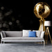Gray sofa with decorative pillows in a room with a large gold soccer ball sculpture.