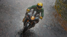 Motorcyclist on a wet road with reflective surfaces