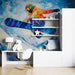Modern room interior with colorful wall mural of a snowboarder, desk, and decorative items.
