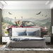 A bright living room space with a scenic convertible driving mural as a feature wall behind a beige sofa.