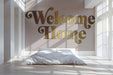 Cozy bedroom wall with gold Welcome Home lettering behind a neutral upholstered headboard