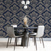 Traditional formal dining room with navy blue damask wallpaper and polished wooden furniture.