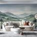 A spacious living room featuring the watercolor landscape wall mural behind a neutral linen sofa.