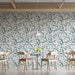 Floral vine mural wallpaper installed in a bright and airy bedroom with wooden furniture