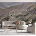 A cozy nursery room featuring the impressionist cat mural on an accent wall behind a white wooden crib.