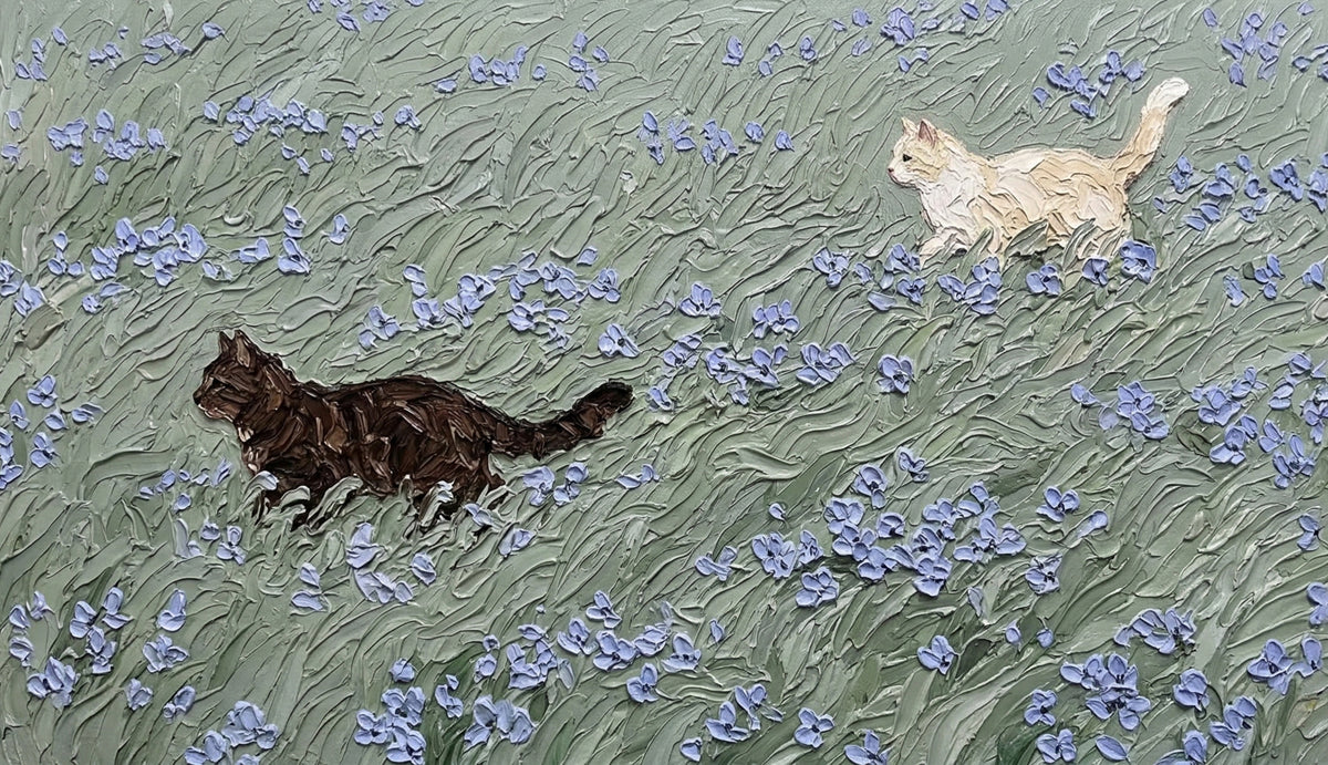 Oil painting style wallpaper featuring cream and charcoal cats in a sage green meadow with periwinkle flowers.
