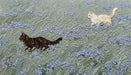 Oil painting style wallpaper featuring cream and charcoal cats in a sage green meadow with periwinkle flowers.