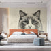 A cozy reading nook featuring the stippled cat mural, complemented by a velvet armchair and wooden side table.