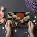Botanical mural with dark foliage and orange accents styled in a formal dining room