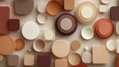 Abstract pattern of textured circles and squares in terracotta, beige, and brown tones.