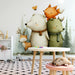 Nursery room featuring a friendly forest animal mural with a wooden crib and soft sage green bedding.