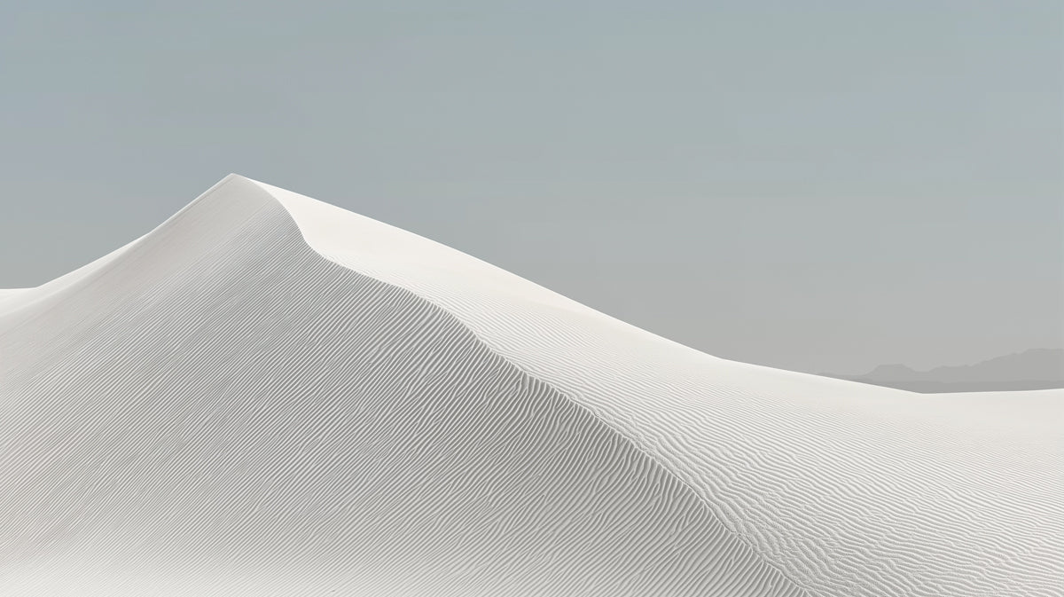 A clean, minimalist mural of a white sand dune with fine ripple textures under a soft, muted gray sky.