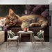 A reading nook with a soft armchair placed against the kitten and floral mural.