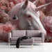 Soft pink unicorn and floral wallpaper installed in a charming nursery with white wooden furniture.