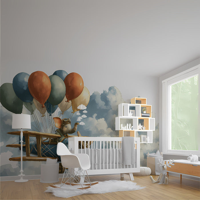 Nursery room wall featuring an elephant pilot mural with blue skies and painterly clouds