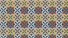 Grid pattern of square tiles with four-leaf floral motifs in terracotta, slate blue, forest green, and charcoal.