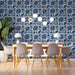 A cozy library reading nook featuring vintage-style blue and cream floral wallpaper.