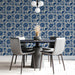 A sophisticated dining room with blue floral damask wallpaper and a long wooden table.