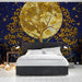 A cozy bedroom with a dark celestial moonlit tree wallpaper behind the headboard.