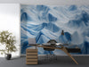 Living room interior featuring an abstract blue and white landscape wallpaper behind a minimalist sofa.