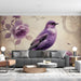 A romantic bedroom featuring the purple bird and rose floral mural behind a tufted headboard