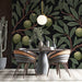A cozy reading nook featuring an olive branch botanical mural on the feature wall behind a velvet armchair.