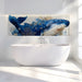 A calming bathroom with a velvet armchair positioned against the detailed aquatic whale mural