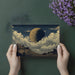 Home office decorated with a dark celestial landscape wallpaper for a studious mood.