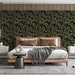 A refined home office with olive-patterned mural wallpaper and warm brass lighting.