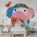 Whimsical elephant wallpaper installed in a bright modern nursery with light wood furniture