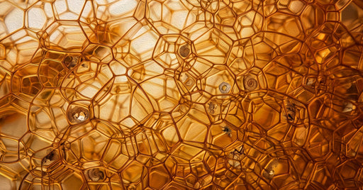 Abstract cellular pattern in shades of glowing amber, golden honey, and dark bronze with an oil-painted texture.