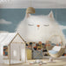 Whimsical cat wallpaper installed in a colorful kid’s bedroom with soft wooden furniture.