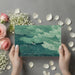 Minimalist bathroom with green coastal line art wall mural