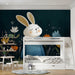 A creative study room wall featuring a dark, whimsical meadow illustration with a rabbit.