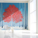 Modern study featuring a bold red tree wallpaper accent wall behind a white sofa