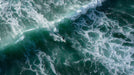 Aerial view of a surfer on a deep turquoise ocean wave with oil painting style brushstrokes