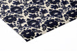 A cozy library with dark navy and cream floral wallpaper