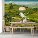 A dining room interior featuring an expansive mountain terrace mural as a focal point.