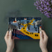 Pointillist style village mural behind a modern living room sofa and accent cushions.
