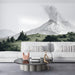 A moody living room interior with a panoramic etched-style volcano landscape wall mural behind the headboard.