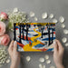 A cheerful entryway wall covered in a folk art village scene that creates a warm and welcoming first impression.