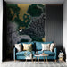Moody home office space with abstract topographic green and gold wallpaper behind a dark wood desk.