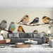 A cozy living room featuring a bird-themed wall mural that creates a gentle and calming environment for infants.