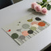Playful bird mural on a dining room feature wall paired with a round light wood table.