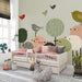 Whimsical bird wallpaper installed in a modern gender-neutral nursery with wooden crib.