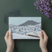 A bright, organized home office with a winter landscape train mural on the accent wall.