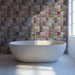 Cozy bathroom interior featuring a soft pink and cream botanical mosaic wall behind a tufted headboard